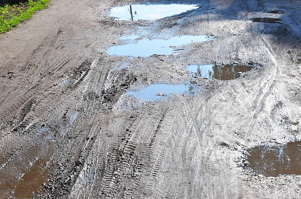 istock Bad Road. Close up on Puddle and Pot hole 594921288