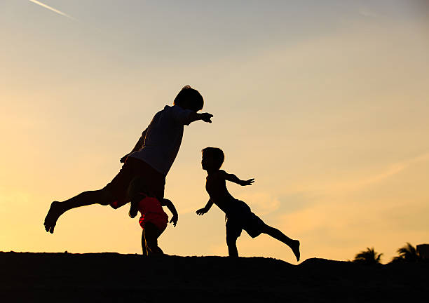 istock father with kids silhouettes having fun at sunset 594922288