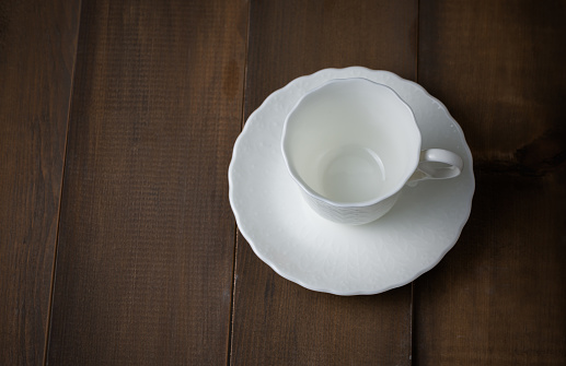 classic white cup of coffee on dark wood background, dark tone
