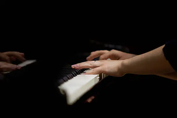 Photo of Hands of a woman playing piano closeup