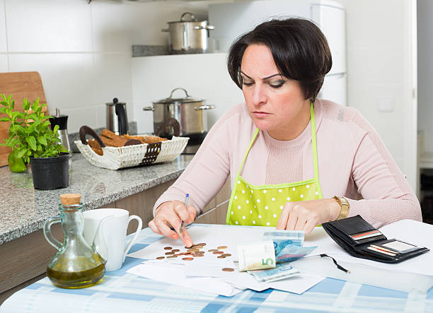 Miserable female counting money for payment Depressed broke woman without enough money to pay bills over spend stock pictures, royalty-free photos & images