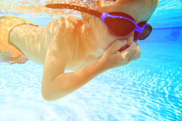istock little boy learns swimming underwater 594923396
