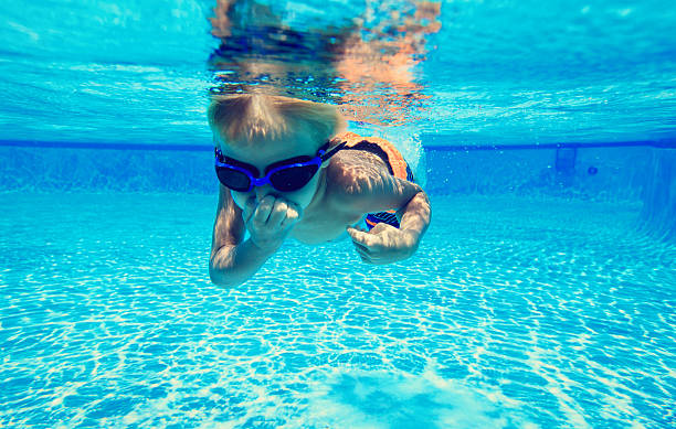 istock little boy learns swimming underwater 594923476