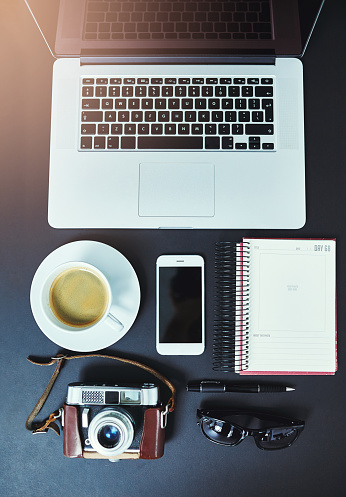 Cropped shot of a creative businessperson's desk with a laptop, camera, smartphone and other objects