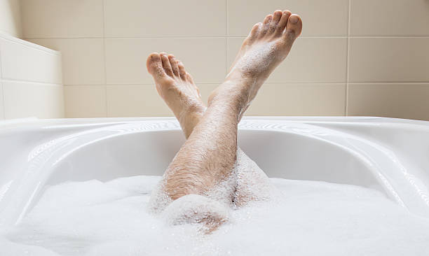 istock Men's feet in a bathtub, selective focus on toes 594924686