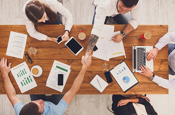 istock Business people group handshake in office, top view 594927294
