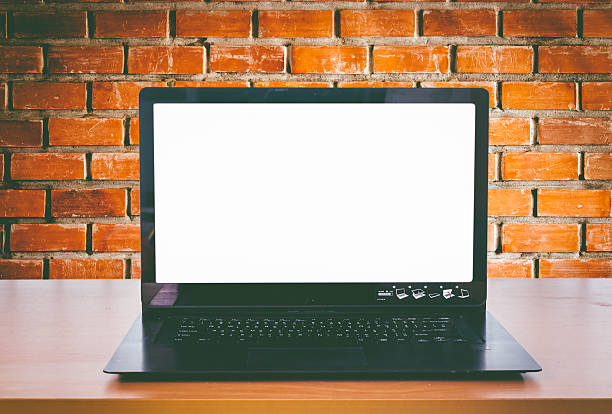 istock laptop on an office desk in front of brick wall 594927836