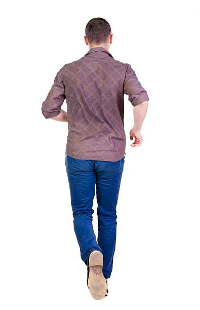 istock Back view of running man in brown shirt. 594927906