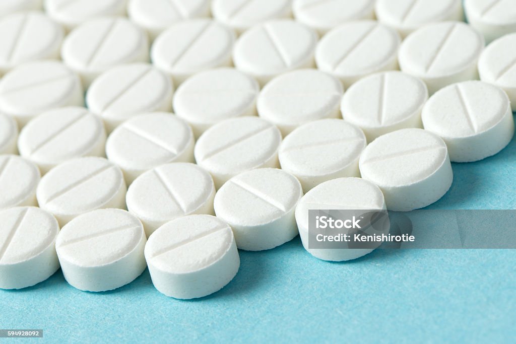 White tablets or medicine Close up of white round tablets on blue background Acetaminophen Stock Photo