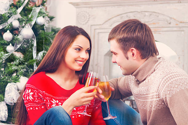 istock Young happy couple drinking champagne by the Cristmas tree 594932076
