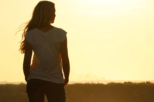 Beautiful woman enjoying sunset on the beach