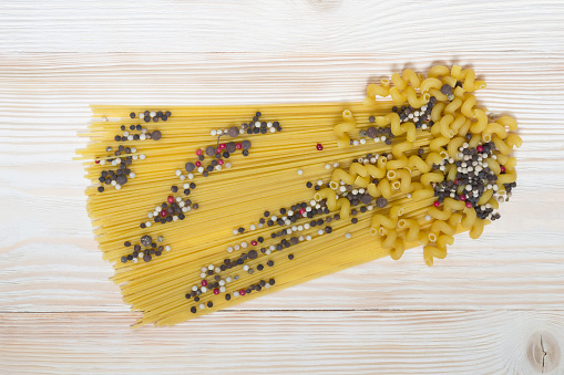 Pasta on the table with seasoning and pepper