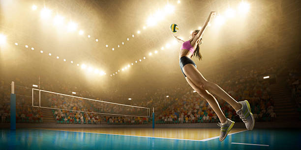 Volleyball: Female player in action Beautiful female volleyball player performs an emotional game moment on the indoor volleyball stadium with bleachers full of people. She is wearing an unbranded sports cloth. womens field event stock pictures, royalty-free photos & images