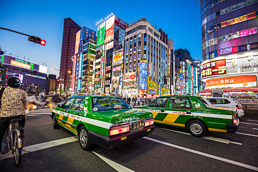 Taxis waiting on a red traffic light in a street of Shinjuku.