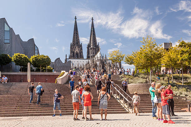 Cologne, Germany - Jul 26, 2012: View from east  (near Rhine riverside) of Cologne Cathedral apse, part of Museum Ludwig and stairways between Heinrich-Böll-Platz and Weltjugendtagsweg, with some people passing through.