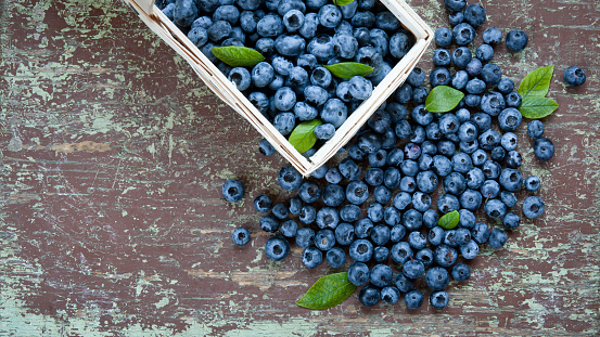 Wooden basket full of fresh blueberries on table