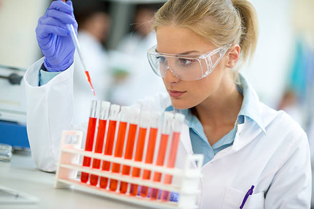 istock Attractive female chemical assistant work with test tubes 594946956