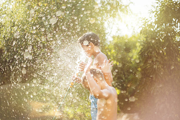 istock Summer portrait of two boys cooling with water 594947342