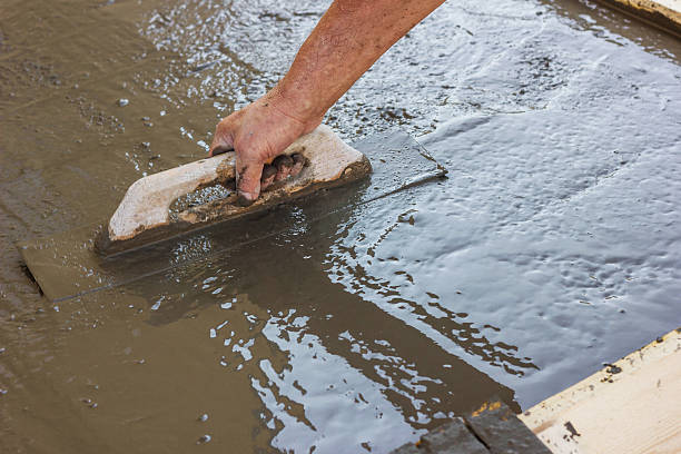istock hand spreading poured concrete and leveling concrete with trowel 594948592