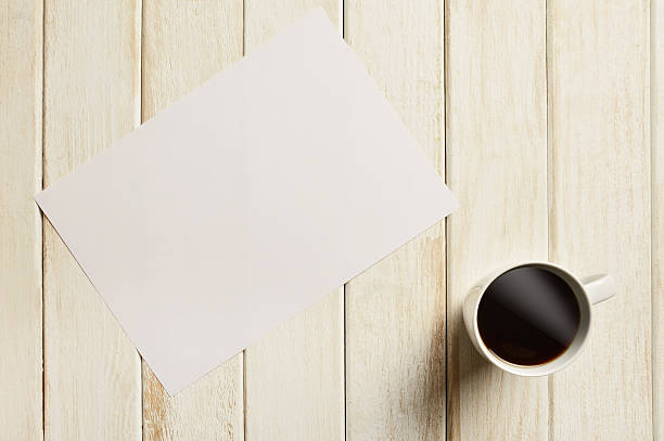 istock Coffee with Blank Paper on White Wood Table 594948840