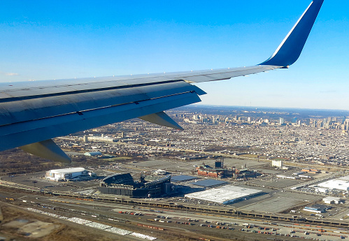 Philadelphia, USA - February 5 205: Plane about to land at Philadelphia International Airport passes over the stadium district of Philadelphia.