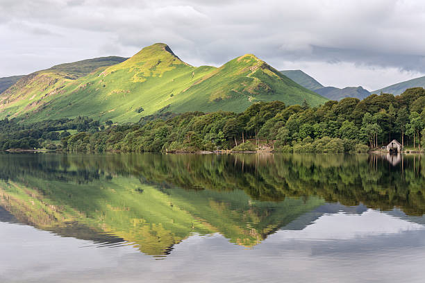 Mountain Peak Reflections In Derwentwater Lake. A scenic view of one the Lake District's favourite views at Derwentwater, Keswick. The image features Catbells mountain, reflected in calm still water. keswick stock pictures, royalty-free photos & images