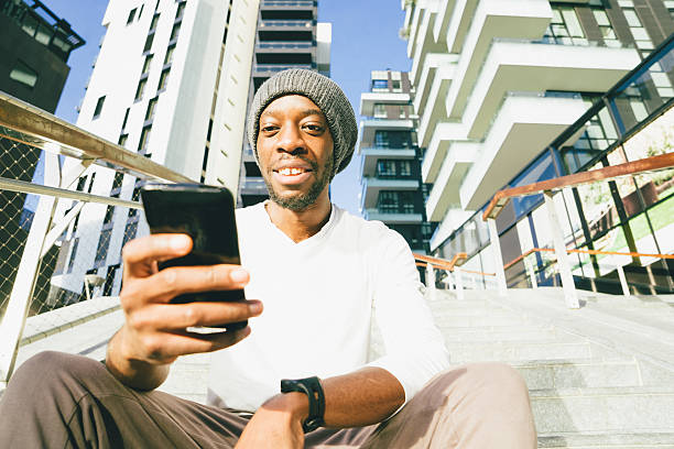 istock Cheerful Young Man Using His Smartwatch And Smartphone 594954008