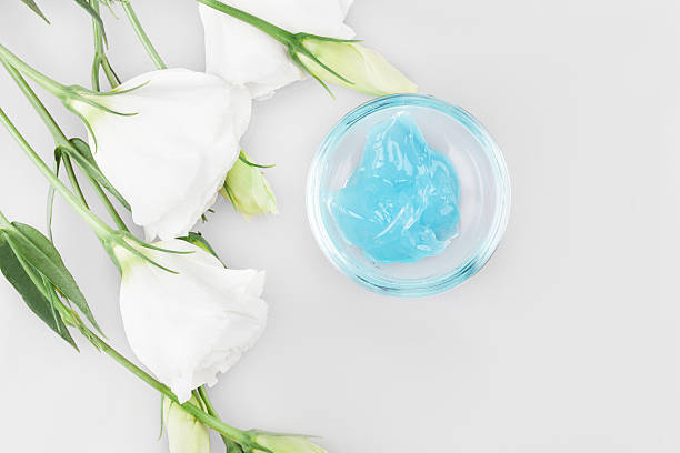 istock blue cosmetic face mask, standing on white background and flower 595097768