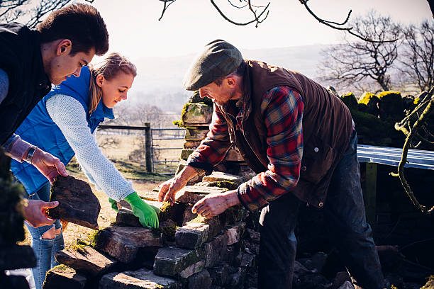 istock Farmer and Children Repairing an Old Stone Wall 595100496