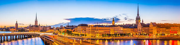 stockholm coucher de soleil éclairé par la lampe hôtel de ville gamla stanspires panorama suède - riddarholmen photos et images de collection