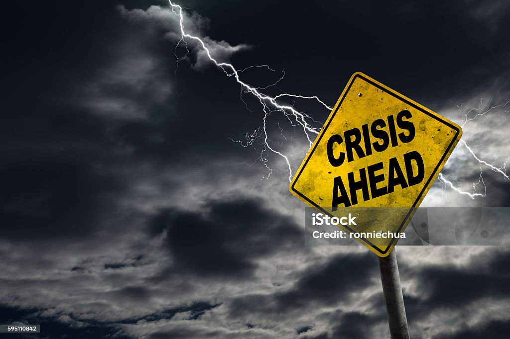 Crisis Ahead Sign With Stormy Background Crisis Ahead sign against a stormy background with lightning and copy space. Dirty and angled sign adds to the drama. Concept of political, financial, social, health crisis, etc. Crisis Stock Photo