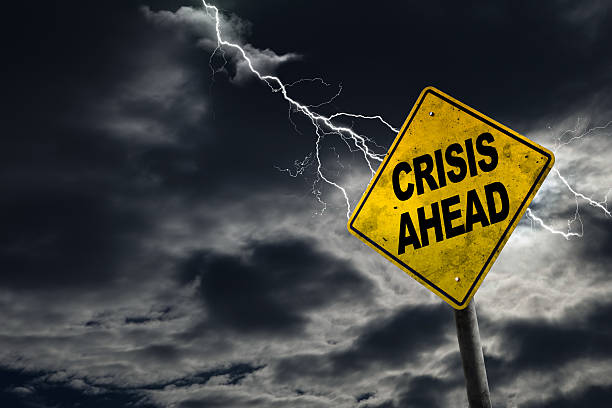 Crisis Ahead Sign With Stormy Background Crisis Ahead sign against a stormy background with lightning and copy space. Dirty and angled sign adds to the drama. Concept of political, financial, social, health crisis, etc. crisis stock pictures, royalty-free photos & images