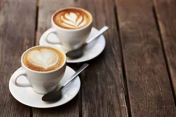 Photo of Two white cups of cappuccino
