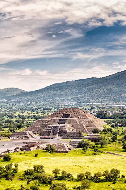 Pre-Hispanic City of Teotihuacan. Mexico. The holy city of Teotihuacan is situated about 30 miles (50 kilometers) northeast of Mexico City. No one knows who did it but it was built aprox 2,100 years ago. The main and largest monuments are the Temple of Quetzalcoatl and the Pyramids of the Sun and the Moon. Those monuments were laid out on geometric and symbolic principles.  The name of Teotihuacan was given to it by the Aztecs and means “the place where the gods were created.”