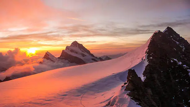 dawn in the Fieschersattel with the sun rising over the Finsteraarhorn ion the Bernese Highlands in the Swiss Alps