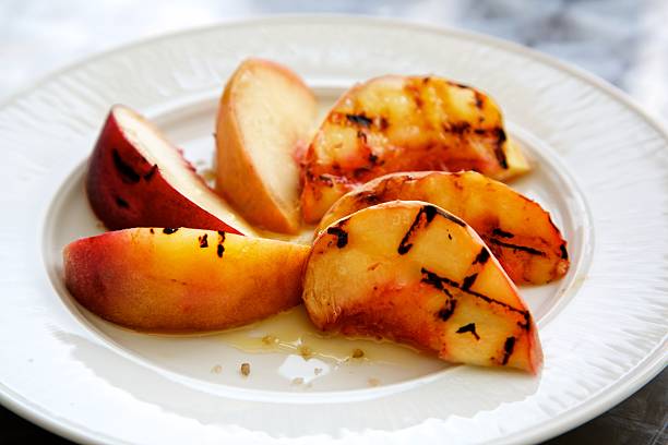 istock Charred and sliced peaches on a white plate 595143182