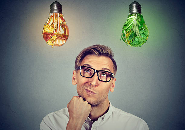 istock Man looking up at vegetables light bulb junk food 595145214
