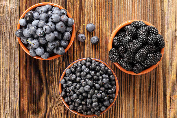 istock Fresh blueberries and blackberries on old wooden background 595145826