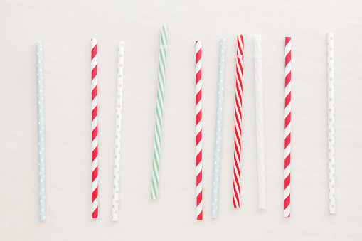  Different drinking straws over white background. Top view, blank space
