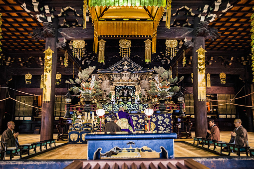 Buddhist monks praying in early morning inside Chion-ji Temple in Kyoto City, Japan.