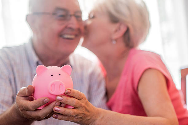 poupança de aposentadoria para casal sênior, segurando cofrinho - pension currency senior adult couple - fotografias e filmes do acervo