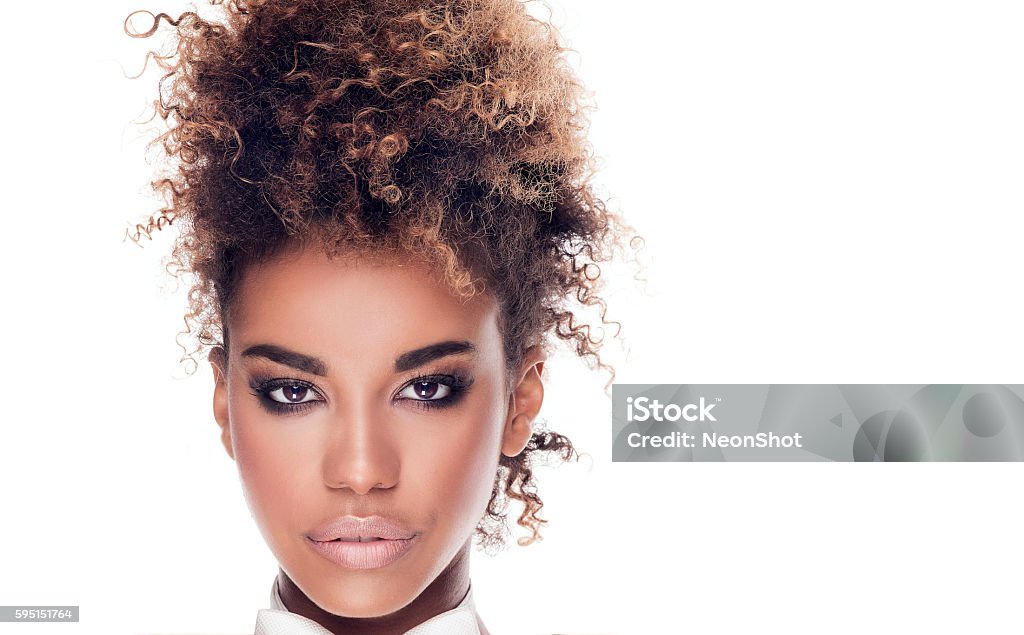 Beauty portrait of elegant african american woman. Beauty portrait of african american woman with afro hairstyle. Girl wearing white bow tie. Looking at camera. Studio shot. White background. Women Stock Photo