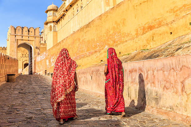 Two Indian women on the way to Amber Fort, India Two Indian women, wearing saris, are going up the way to Amber Fort near Jaipur, Rajasthan.  Amber Fort is located 13km from Jaipur, Rajasthan state, India. It was the ancient citadel of the ruling Kachhawa clan of Amber, before the capital was shifted to present day Jaipur. amber fort stock pictures, royalty-free photos & images