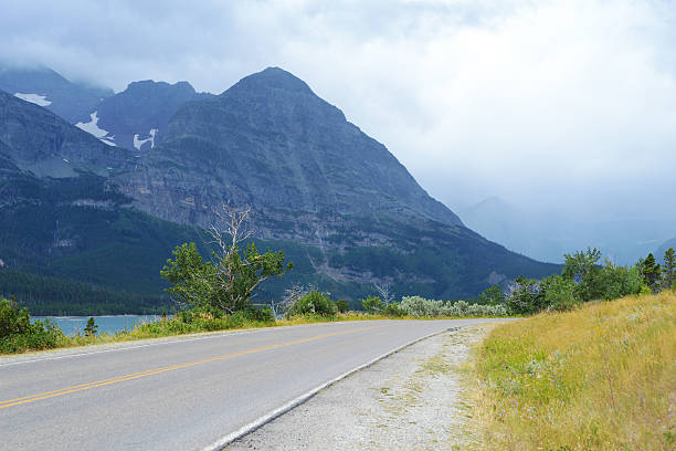 istock Dirt Road leading into mountains in Glacier National Park. 595152828