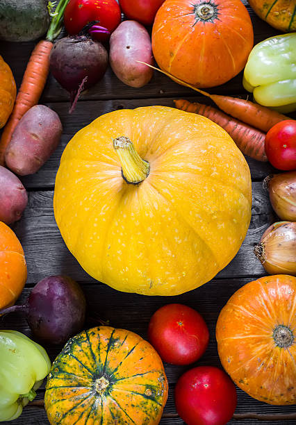 istock Pumpkin and other vegetables on wooden background 595153342