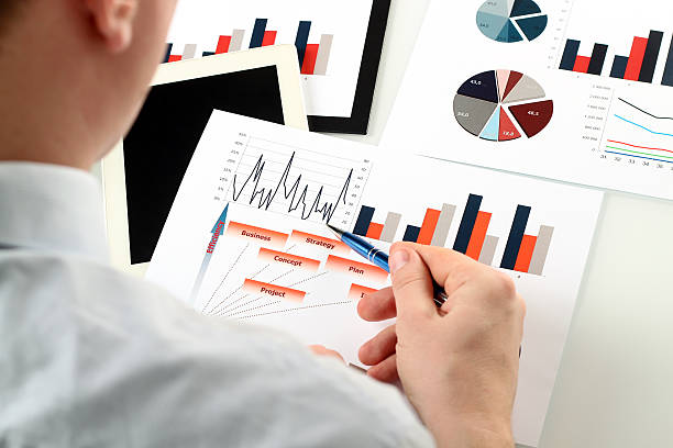 istock young businessman showing graphs by pen 595153658