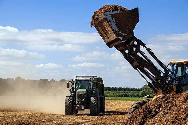 istock excavator with organic fertilizer ready to fill the trailer 595155282