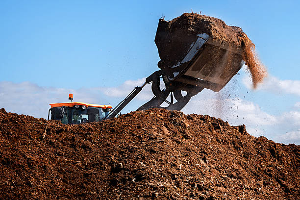 Excavator shovel working on a large heap of, organic fertilizer stock photo
