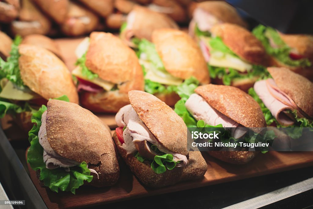 Beautifully decorated catering banquet table with sandwiches Beautifully multicolored decorated catering banquet table sandwiches, sandwich on corporate party event or wedding celebration. Sandwich Stock Photo