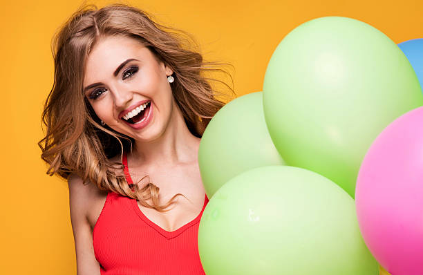 istock Girl with balloons posing in studio. 595159740